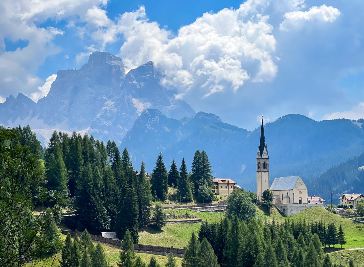 A beautiful Italian church sits in front of incredible jagged mountain peaks near the road that climbs to Passo Giau in Italy's Dolomite mountains. Cycling Passo Giau near Cortina d'Ampezzo in Italy's Dolomites mountains is a rite of passage for road cyclists around the world. Ride Passo di Giau with Alter Exploration on upcoming Secret Dolomites cycling tours.