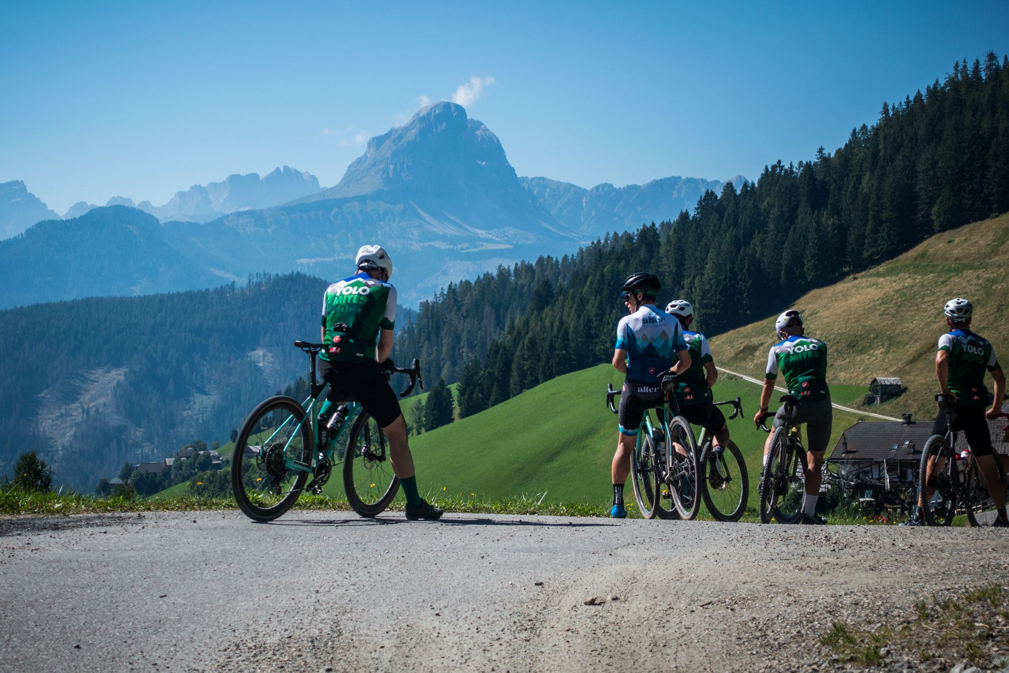 A group of cyclists pause on a gravel road to check their location in Italy's Dolomites during the YOLOmites5000 bike ride. YOLOmites5000 is a backroads Dolomites cycling route that climbs 5,000 meters in just 80 miles (129 km). Founded by Igor Tavella of Hotel Ustaria Posta, this challenging ride is in September each year and set to the rising and setting of the sun. This is one of the most beautiful road and gravel cycling routes in Alta Badia and indeed in Italy's Dolomites.