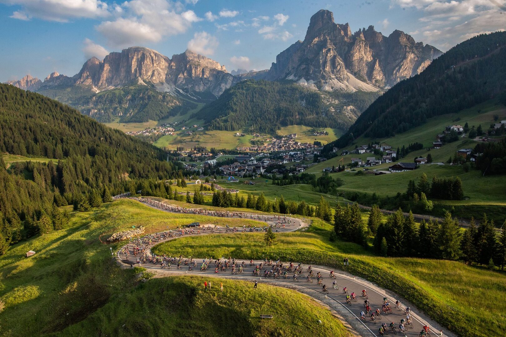 The peloton of cyclists climbs Passo Campolongo above Corvara in Badia during the Maratona dles Dolomiti, one of the most popular, demanding, and gorgeous gran fondo cycling events in the world.